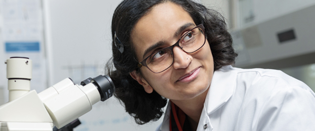 An infectious disease resident at Mayo Clinic examines the human immunodeficiency virus under a microscope.