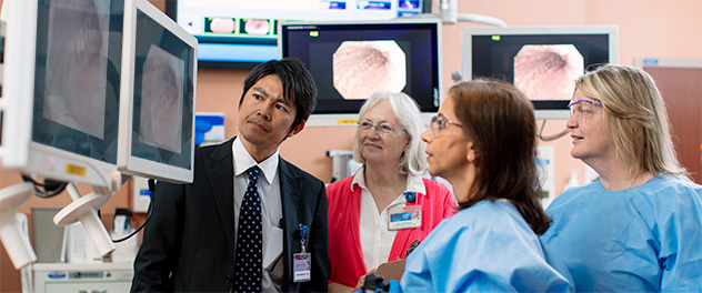 Dr. Rajan and three lab members at Mayo Clinic looking at a monitor