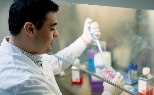 Trainee pipetting liquid for study in lab