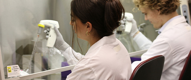 Photograph showing 2 lab members conducting research