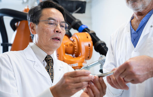 A photograph of a researcher wearing a white lab coat in a lab related to the Department of Defense Medical Research Office at Mayo Clinic