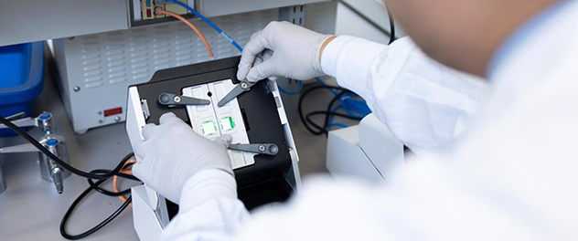 A lab technologist loads microscope slides into the 10x Genomics CytAssist device.