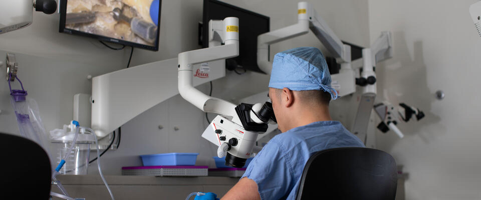 Surgeon using microscope in temporal bone lab