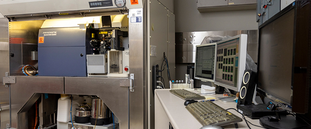 A BD FACSAria IIu cell sorter digital flow cytometer system is shown within a safety hood. The accompanying computer workstation is shown next to it.