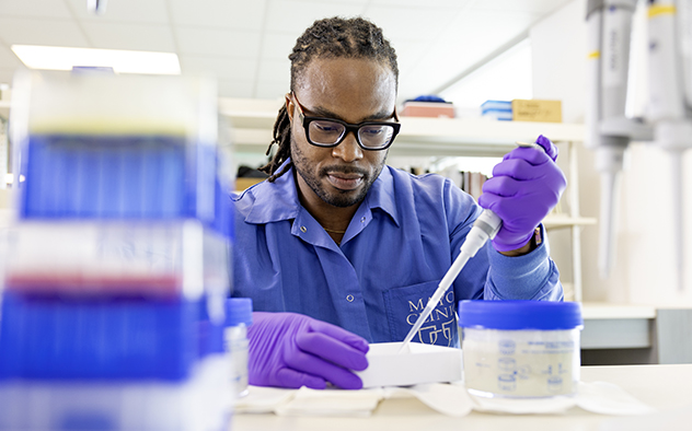 Dr. Akinduro in the lab with a pipette.