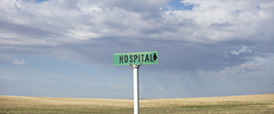 A small 'Hospital' sign is shown outdoors in a rural area.
