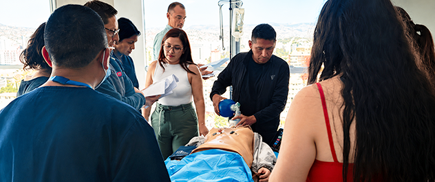 Bolivian CERTAIN participants and trainers work with a mannequin in a simulation exercise.